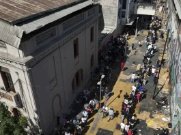 Suspenden enrolamiento de migrantes tras caos en el Estadio Víctor Jara.